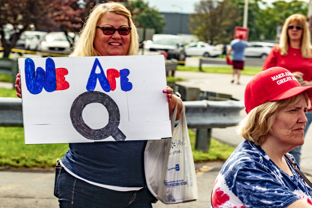 WILKES-BARRE, PA - AUGUST 2, 2018: A woman holds a "We Are Q" sign while in line to attend the "Make America Great Again" rally held at the Mohegan Sun Arena.