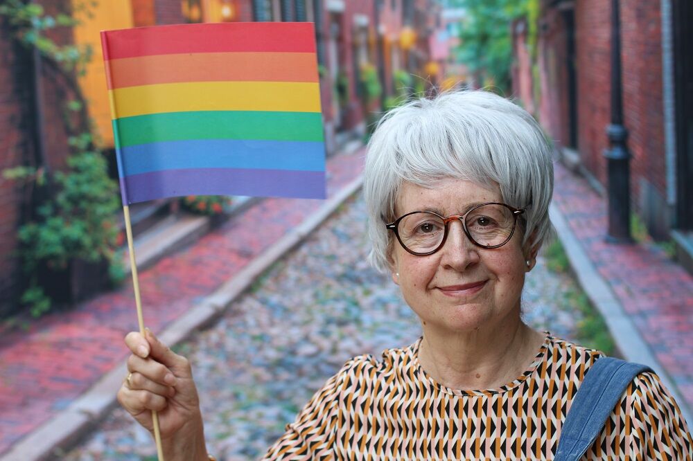 An older woman with a rainbow flag