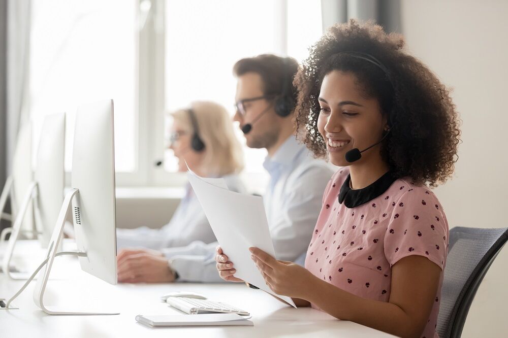 A woman in a call center conducting a poll, but she's too happy for this to be a poll about Trump and Biden