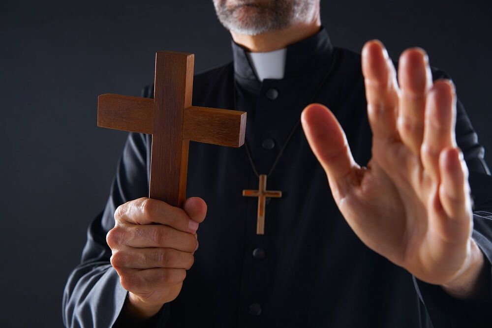 A Catholic priest doing an exorcism... I mean, it's obviously a stock photo and the priest is kinda hot and he's holding a wooden cross, although you can't really see his face. And he's not a priest, he's just a model.