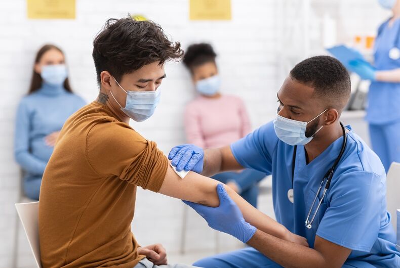 coronavirus-vaccine-doctor-facemask A doctor with a facemask gives a vaccine to a patient with a mask
