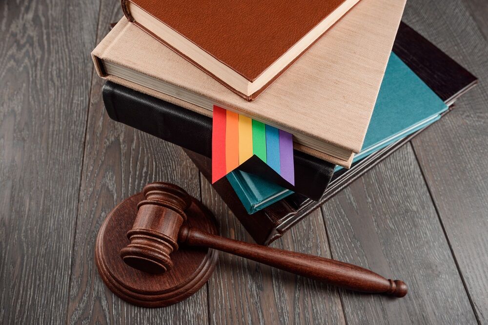 A gavel and a rainbow bookmark in a law book
