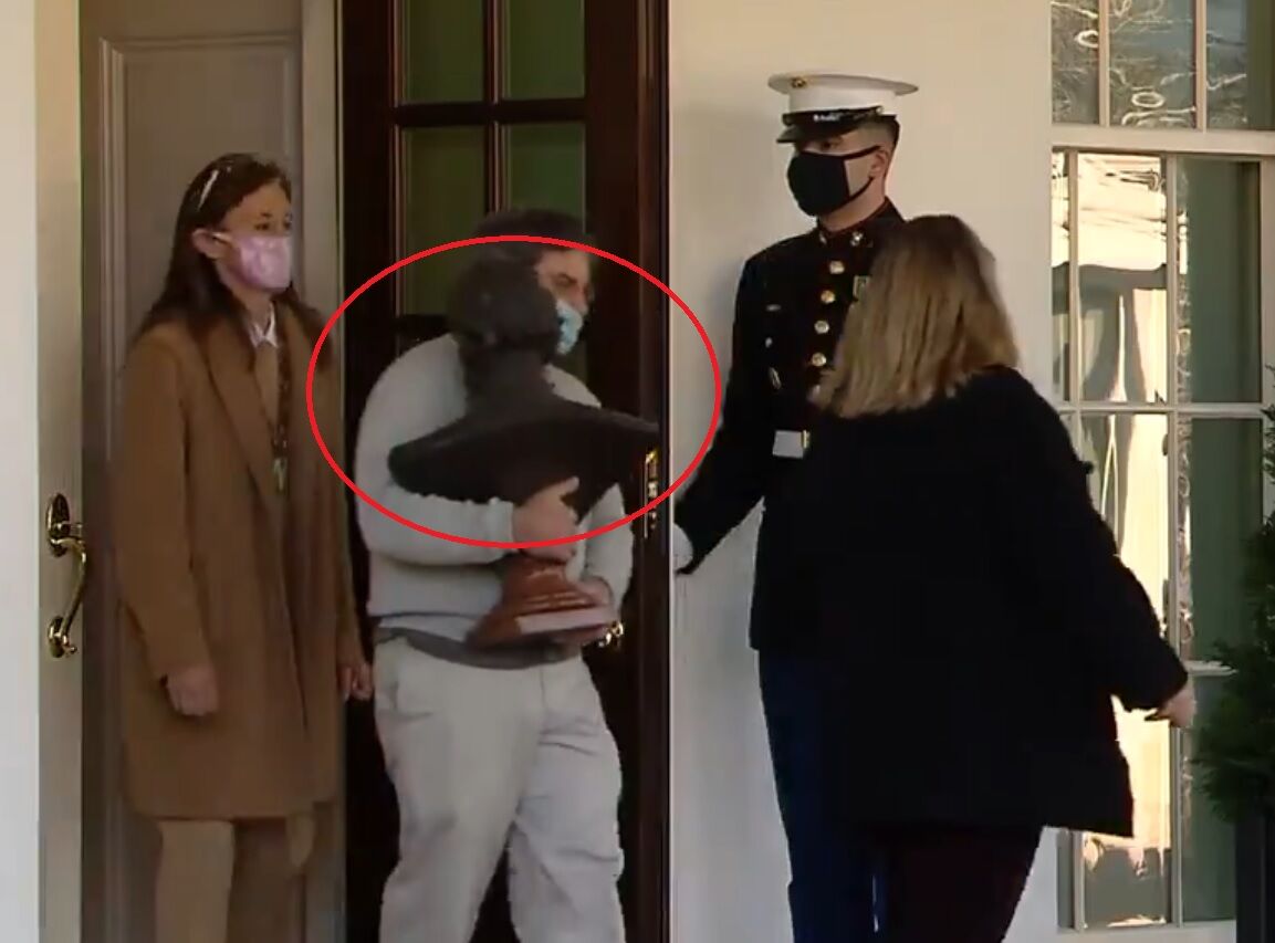 A staffer appears to be leaving the White House with a bust of Abraham Lincoln