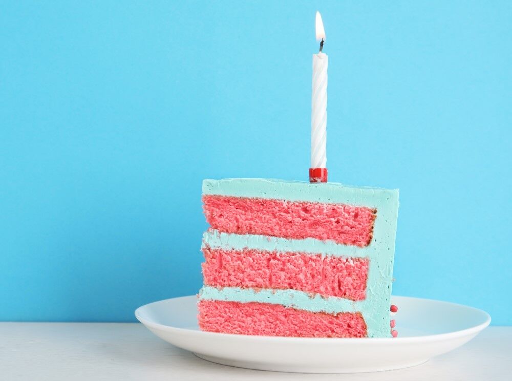 A pink cake with blue frosting