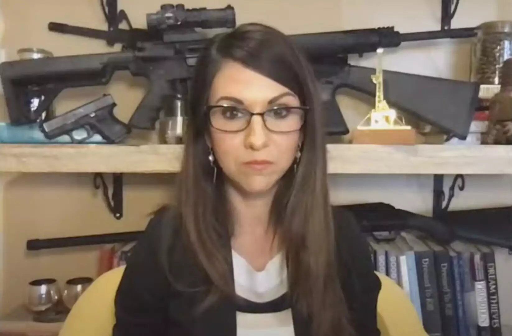 Rep. Lauren Boebert (R-CO) poses in front of a bunch of guns because she thinks it makes her look tough