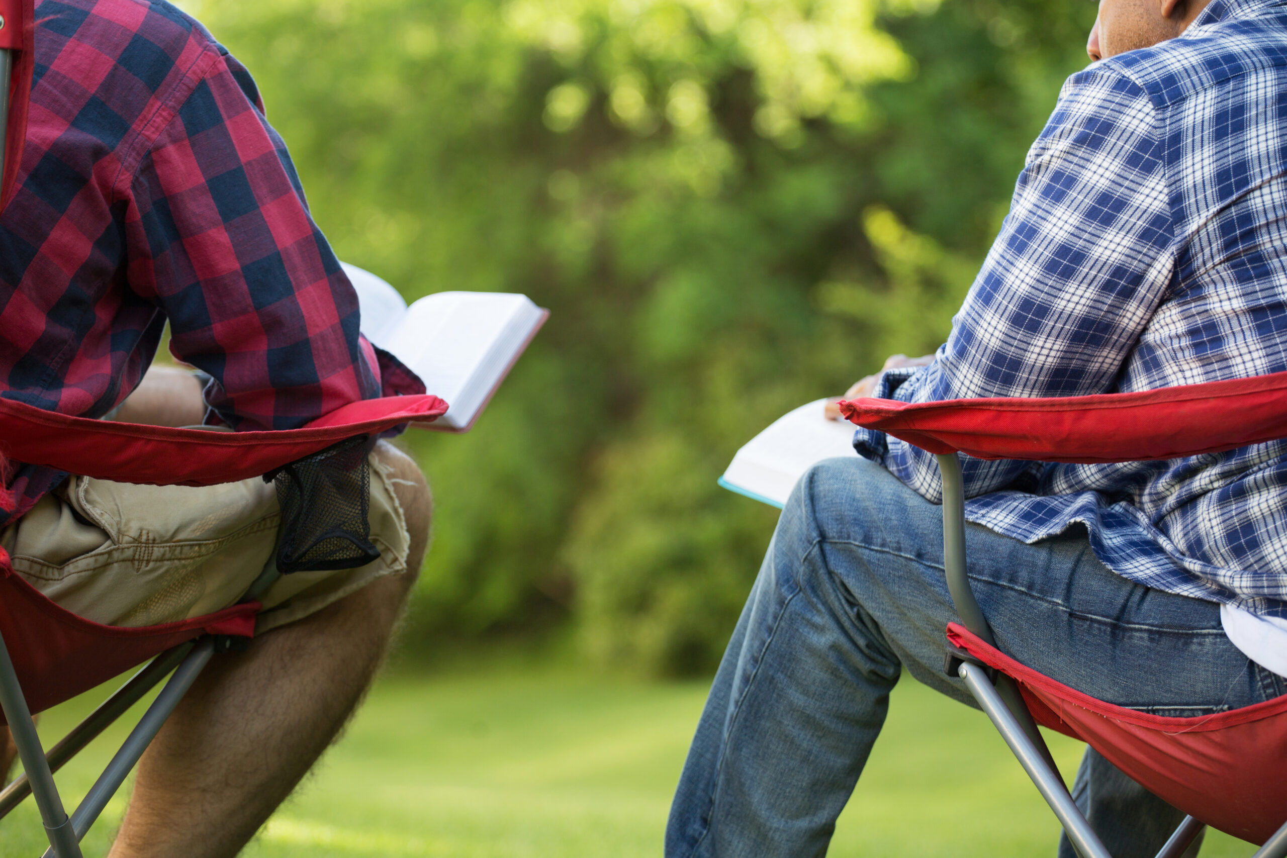 Men having a bible study on a camping trip.