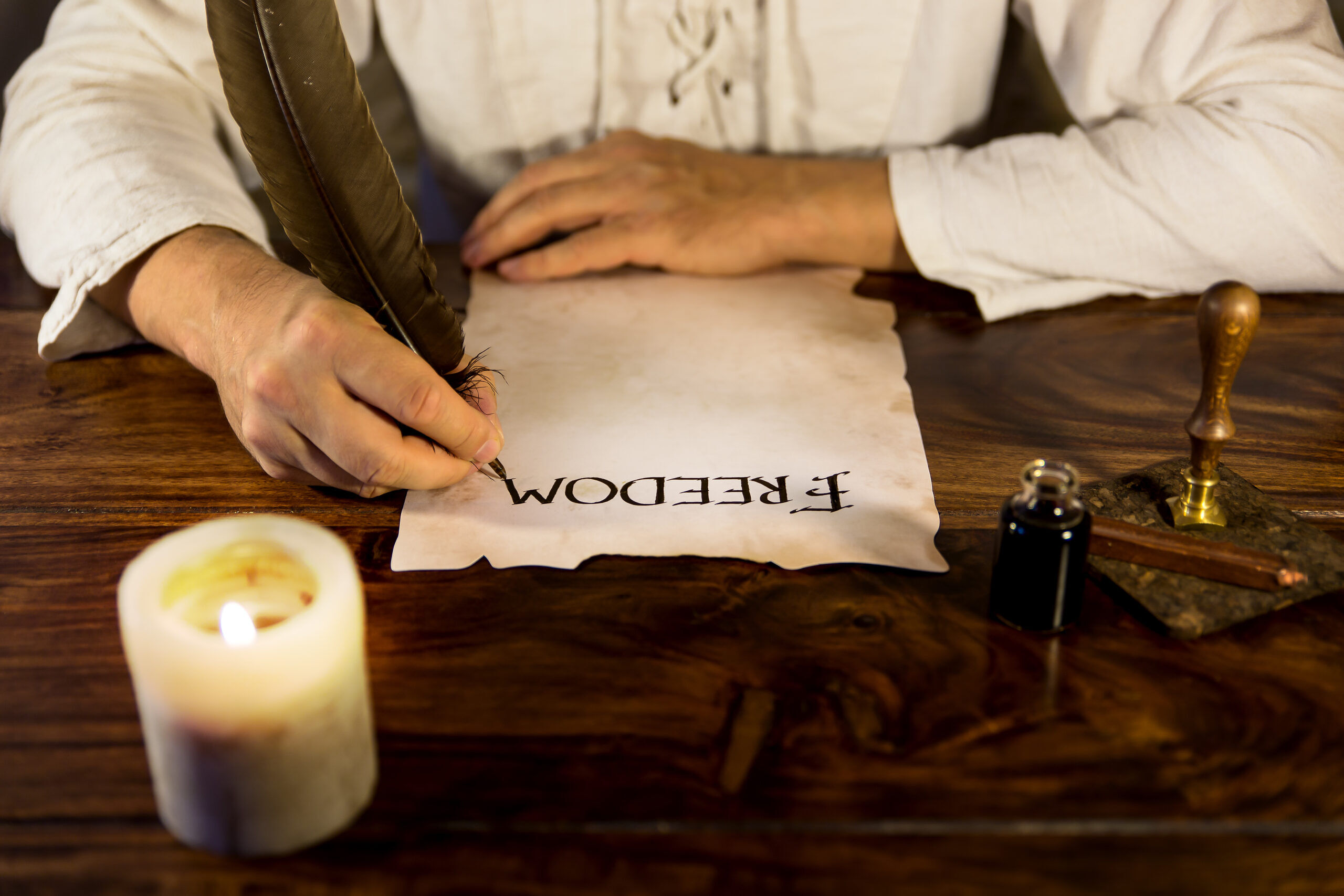 Man writing on parchment paper: freedom