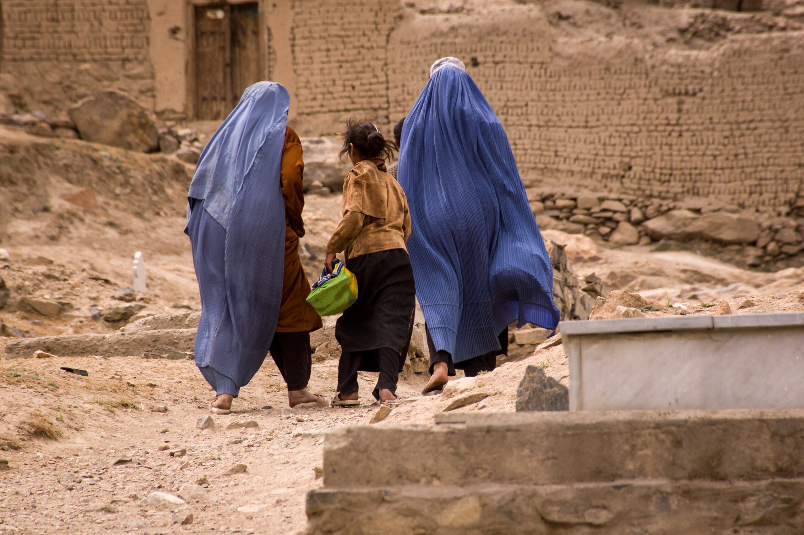 Two women and a girl walk through a graveyard in Kabul, Afghanistan