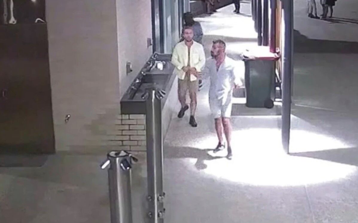 The men leave the restroom after allegedly raping the victim, butting up their clothes.