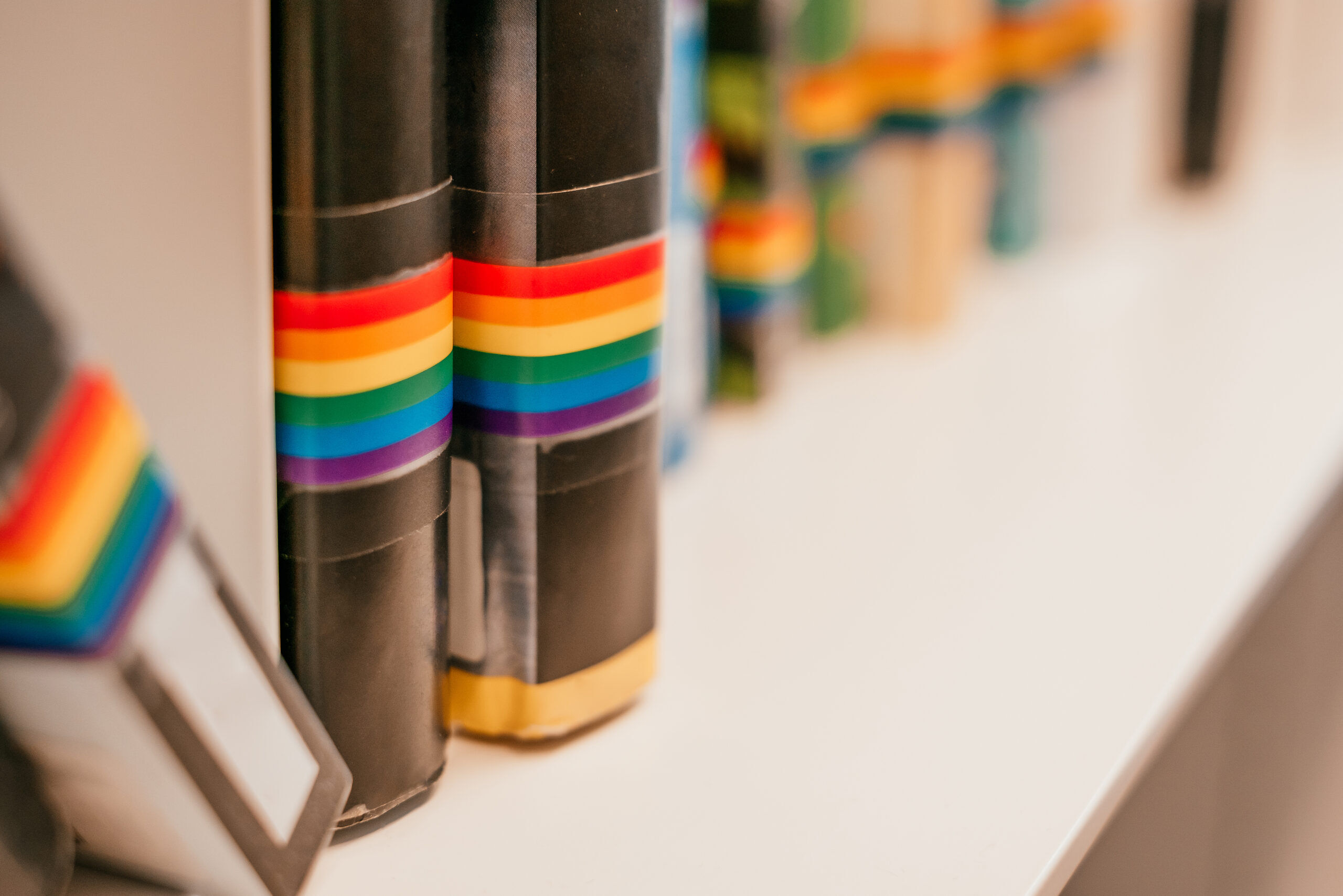Books with rainbow binding on shelf