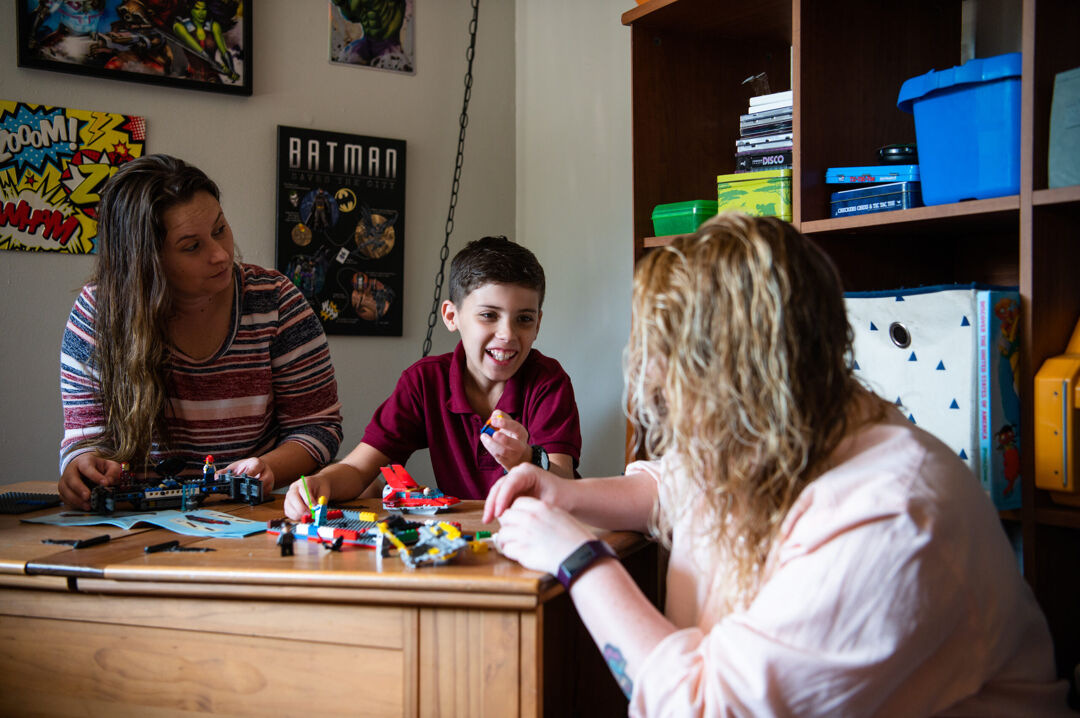 Two moms and son building LEGO