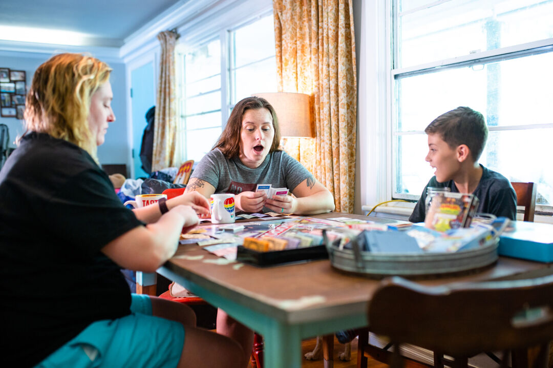 Two moms and son playing board game
