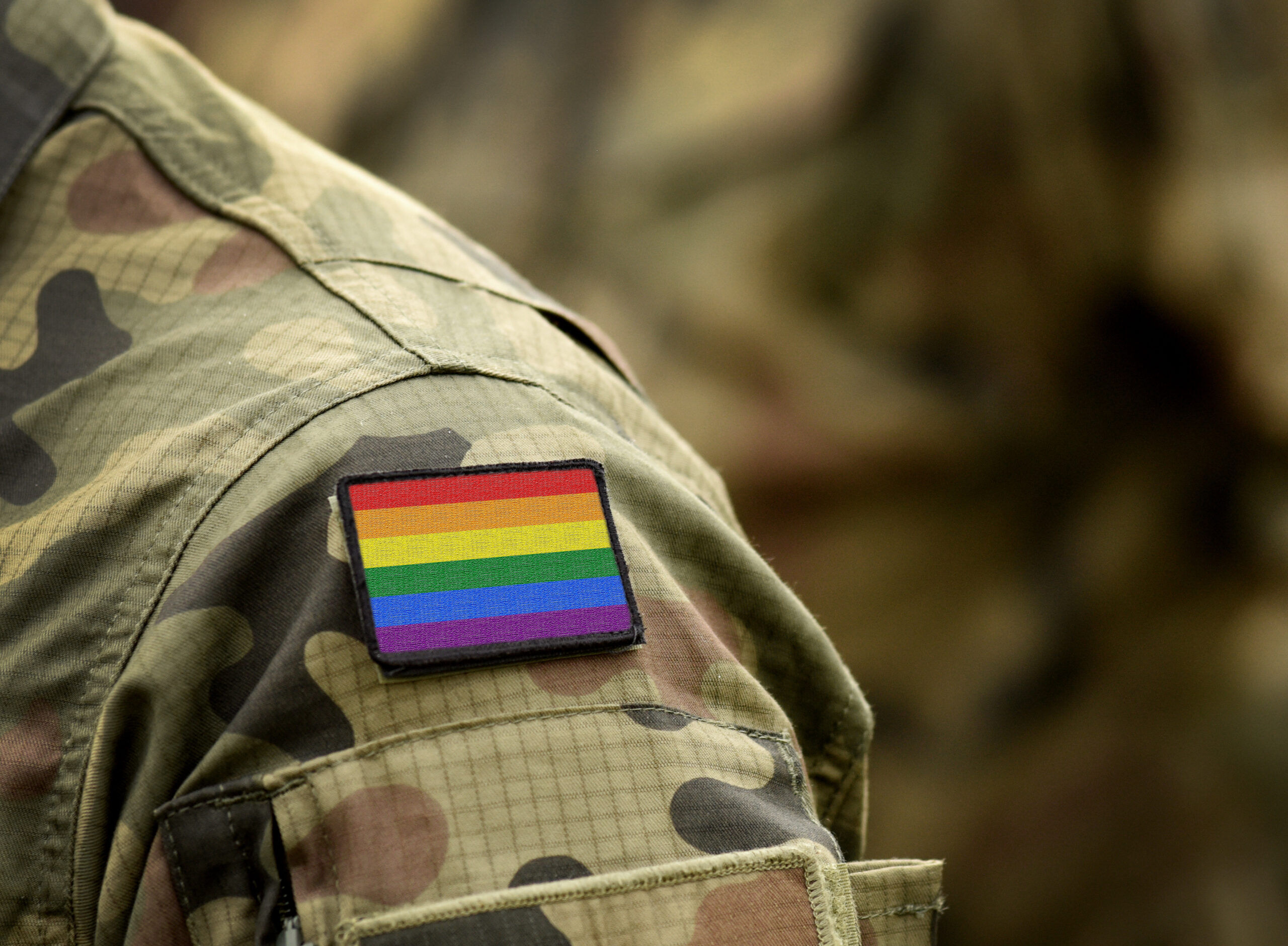 Shoulder of a soldier wearing a rainbow flag patch on his uniform