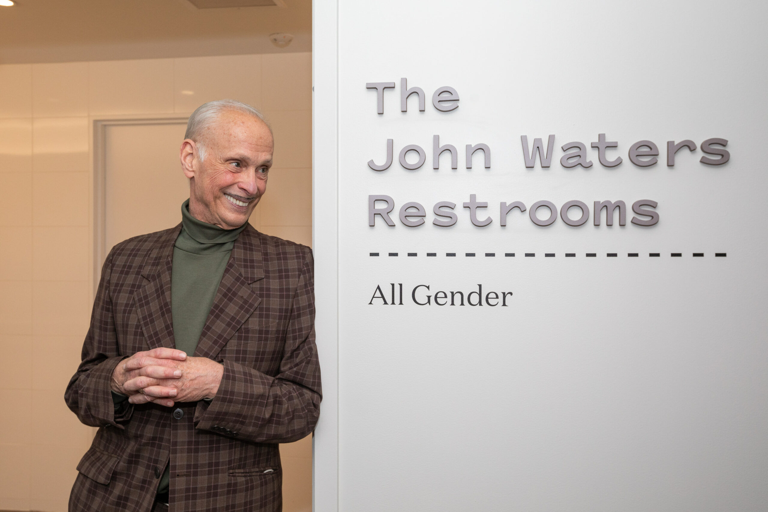 John Waters at the entrance of the Baltimore Museum of Art's "The John Waters Restrooms."