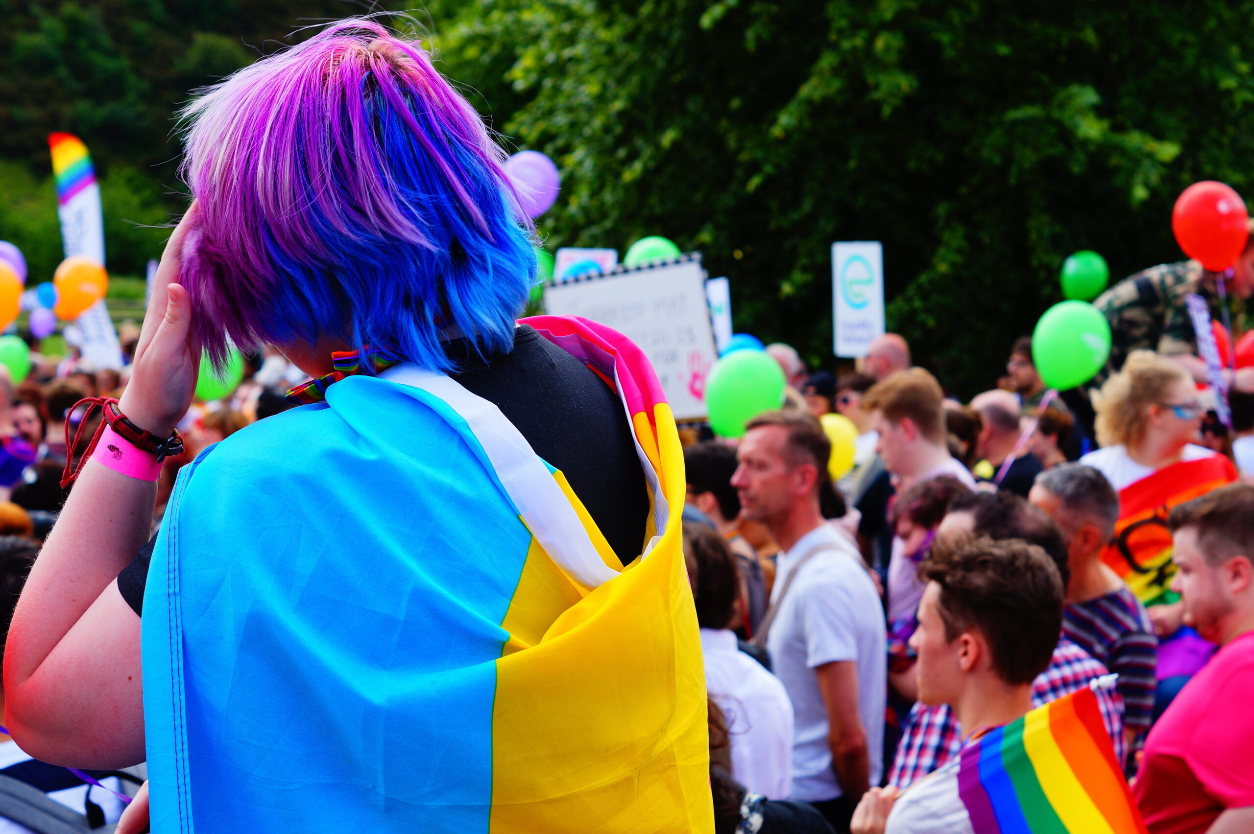Edinburgh, Scotland - June 17 2017: Young person with coloured hair and pansexual pride flag around shoulders at Edinburgh Pride March