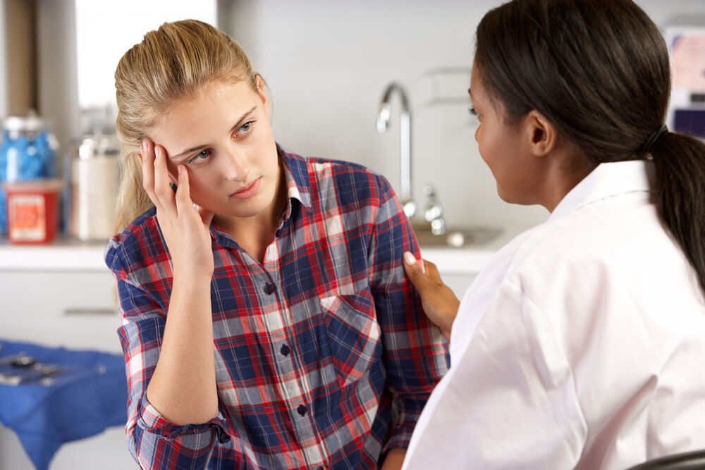 Teen in plaid visiting a doctor. Will she talk about her medical needs? If she's queer, she's less likely to, but this is also a stock image so no, she's not saying anything.