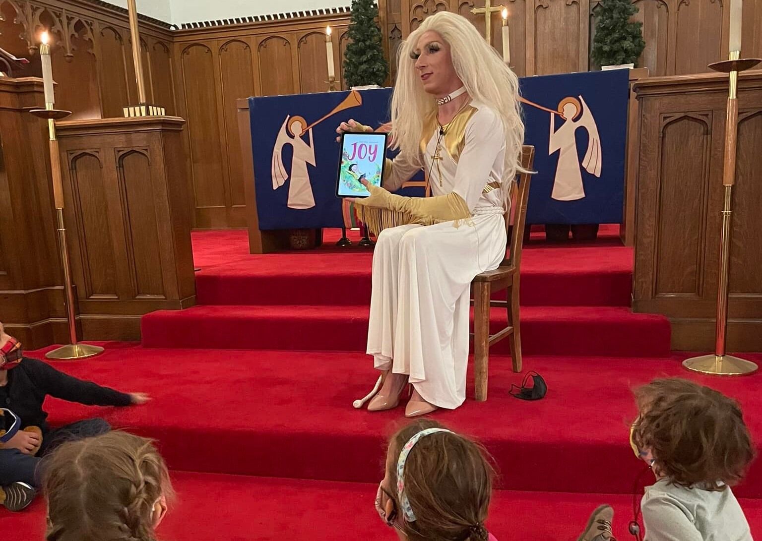 Pastor Aaron Musser reading to children in drag.