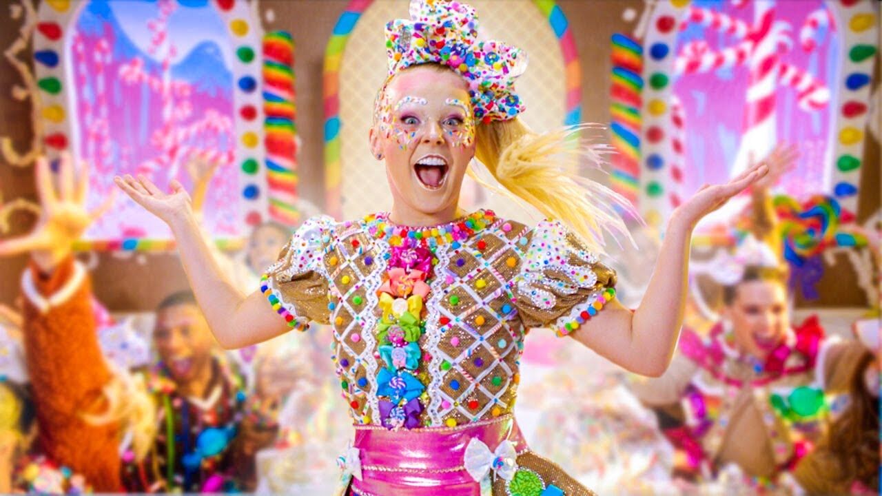 JoJo Siwa decked out in rainbow colors while excitedly performing