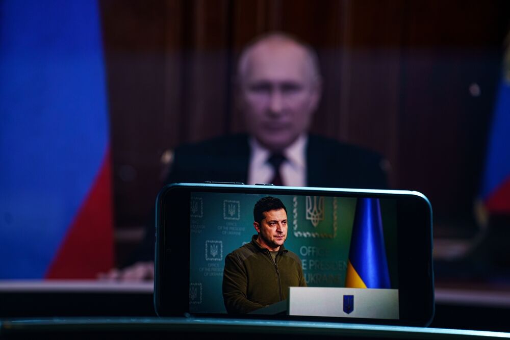 Volodymyr Zelensky, Ukrainian president on television. Russian President Vladimir Putin behind him.