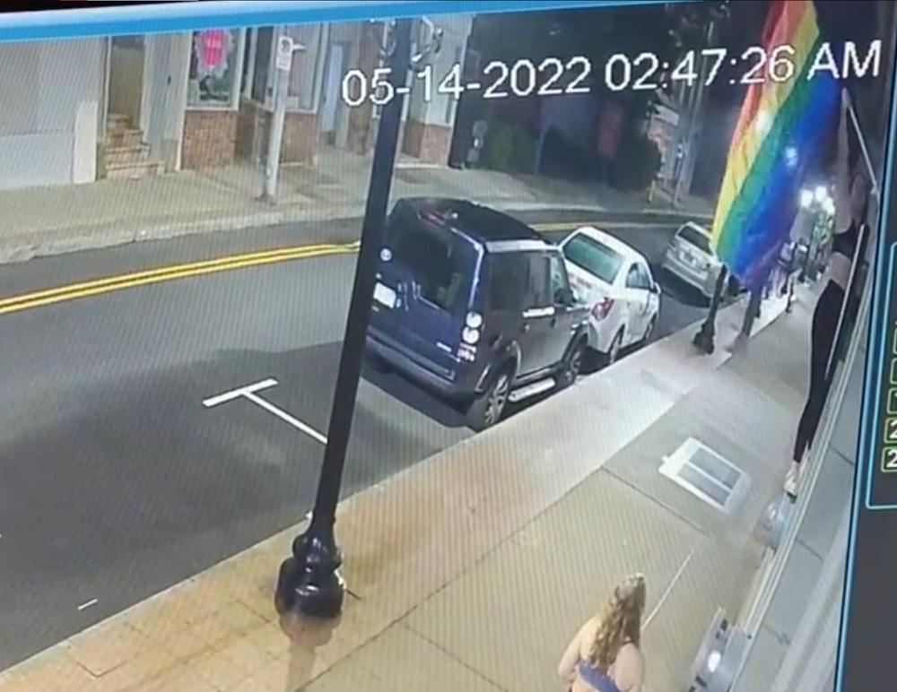 Woman climbs up on windowsill to steal gay husbands’ rainbow flag