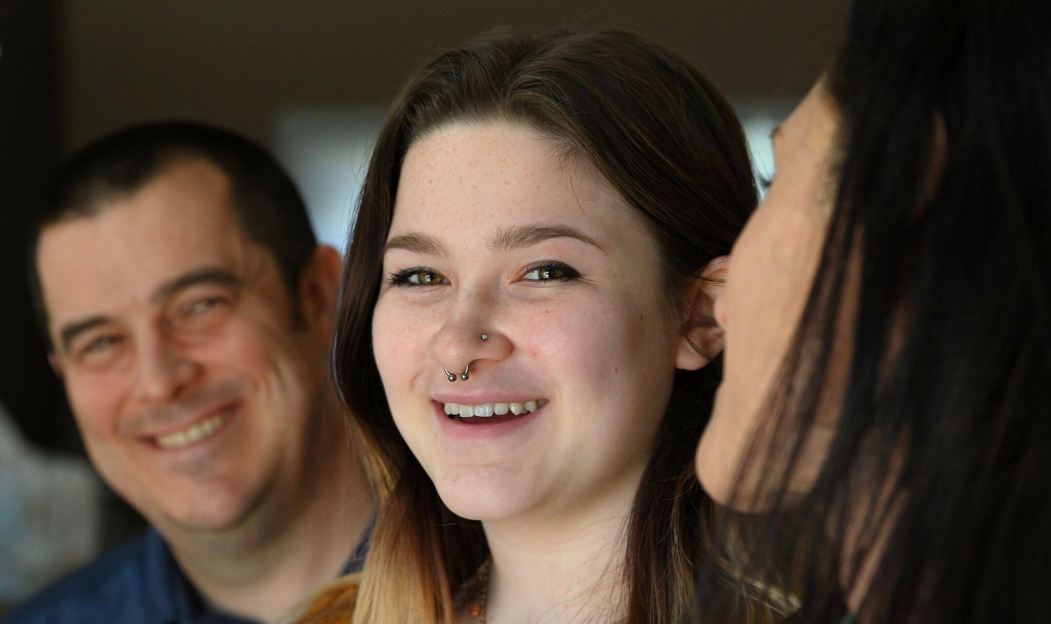 Molly Pinta, center, at home with parents Bob, left, and Carolyn in Buffalo Grove, Illinois, in 2022. Photo by Karie Angell Luc for LGBTQ Nation