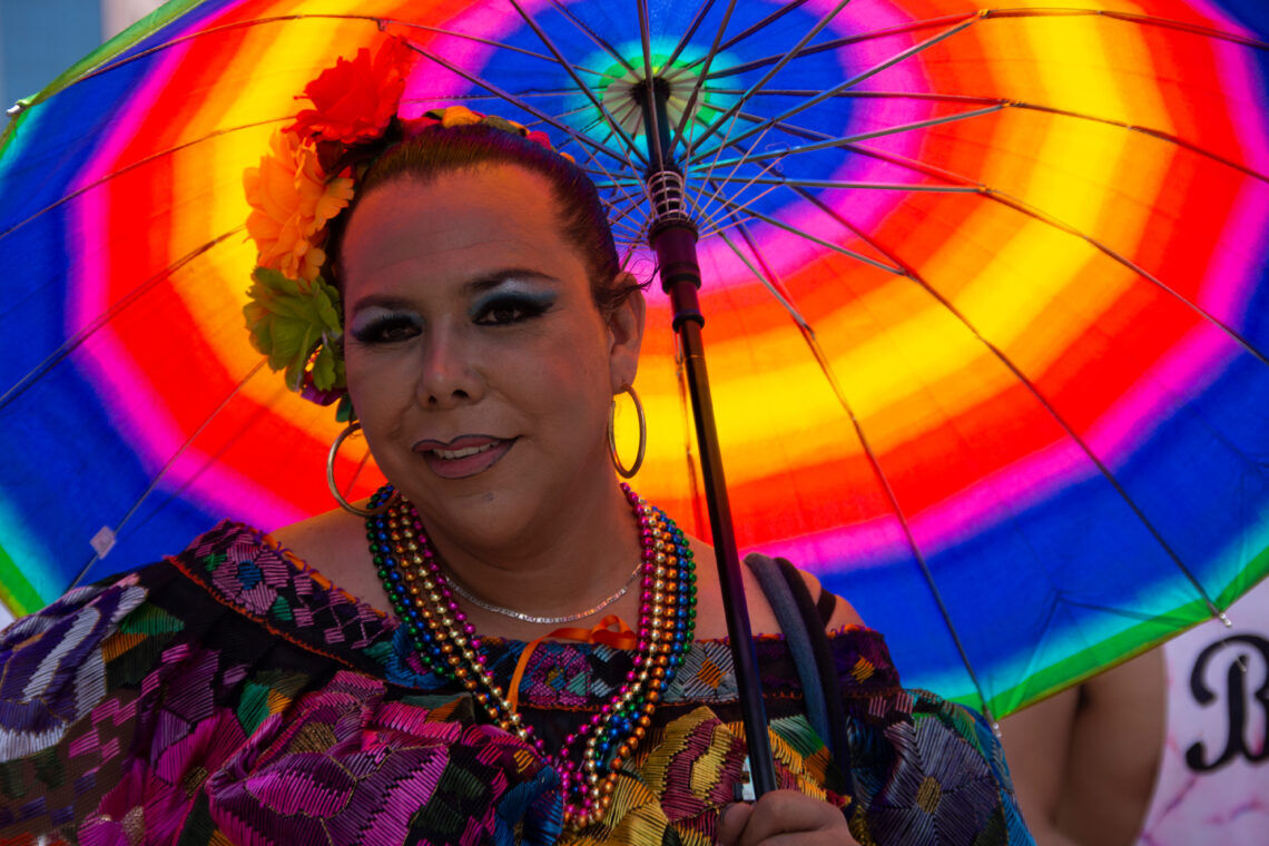 Portrait of a Muxe during the gay parade with colored umbrella. Mexico City, Mexico. June 24, 2017