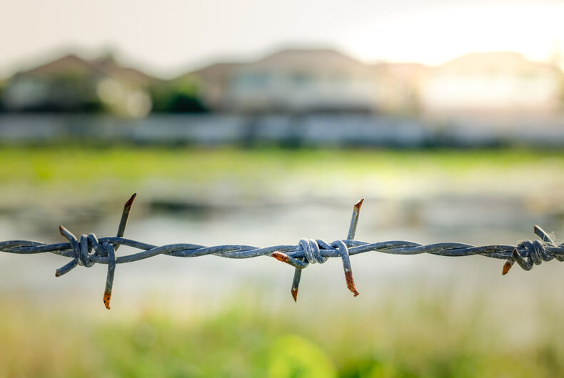 Barbed wire in front of housing