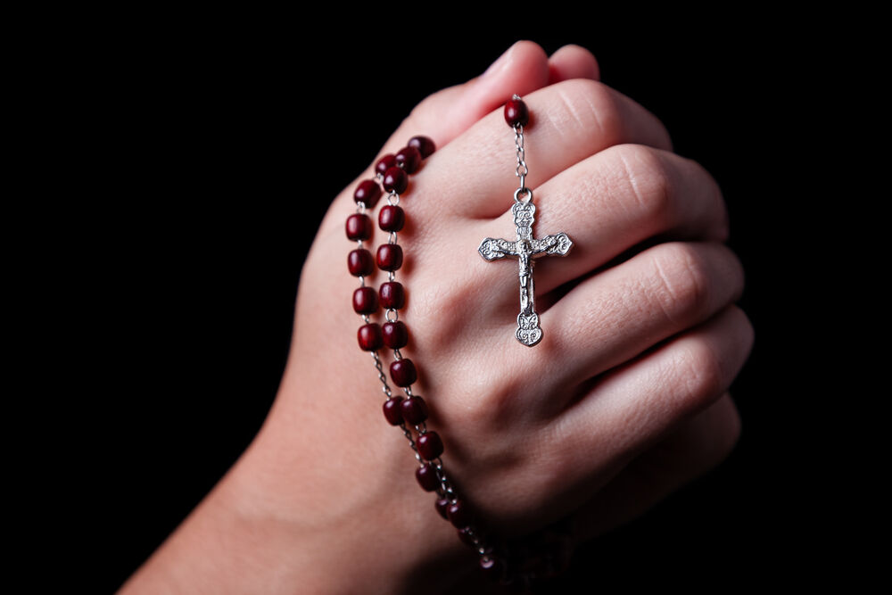 Someone praying with a rosary