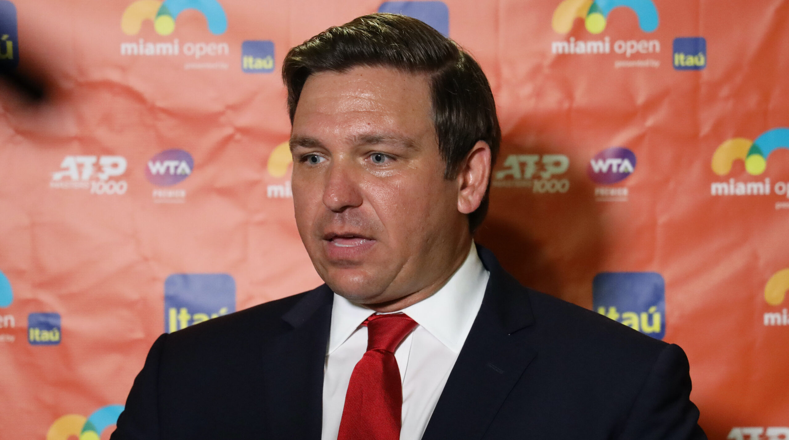 Ron DeSantis wearing a suit and red tie.
