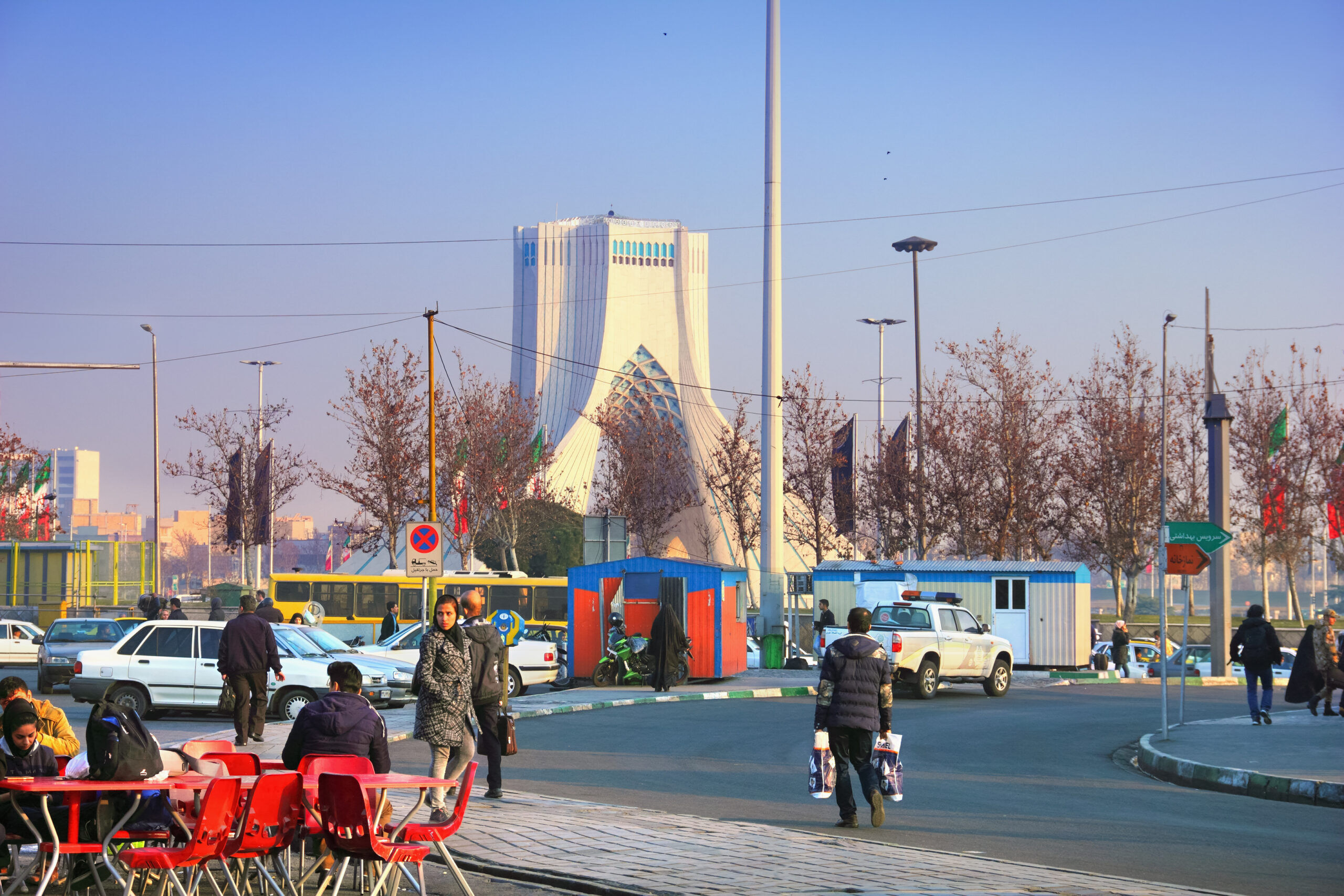 Unidentified people walk along the street in the shadow of Azadi Tower on January 9, 2019 in Tehran, the capital of Iran.