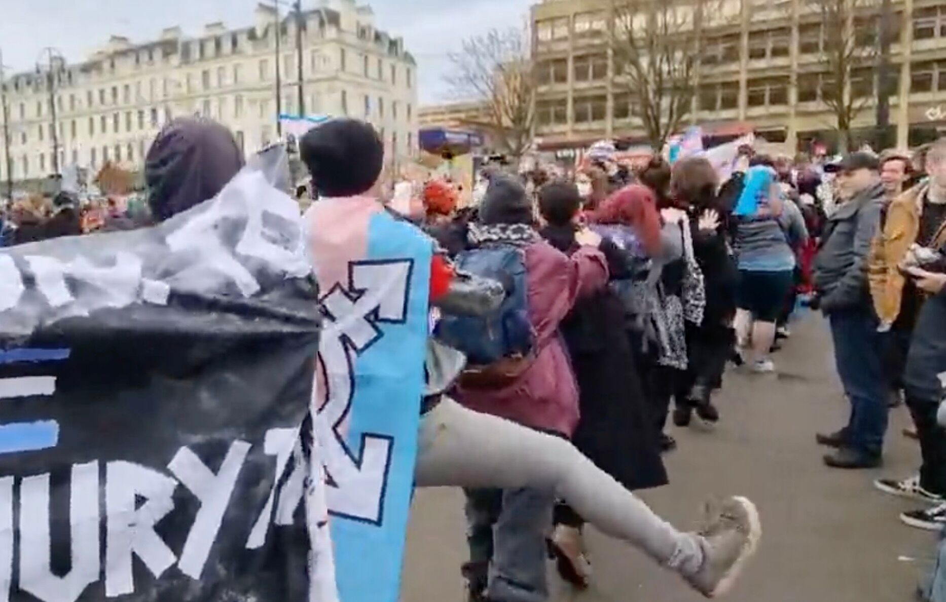 Counterprotests conga and sing "trans rights" to drown out a TERF rally led by Posie Parker