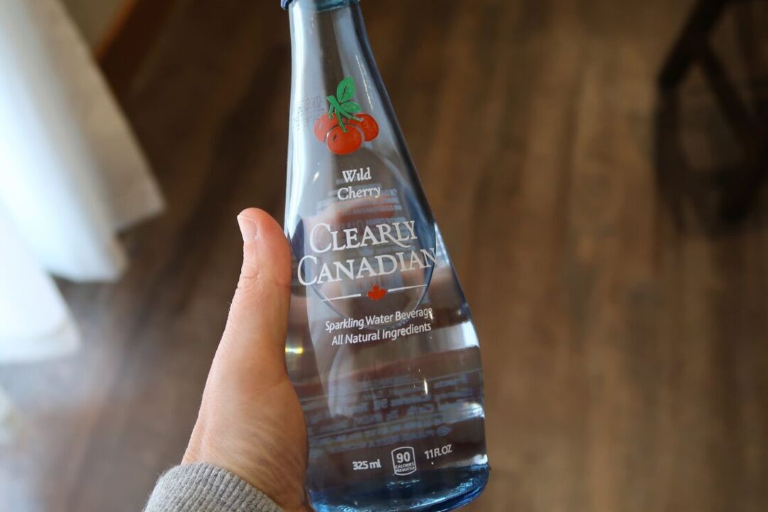 a bottle of Clearly Canadian in a person's hand