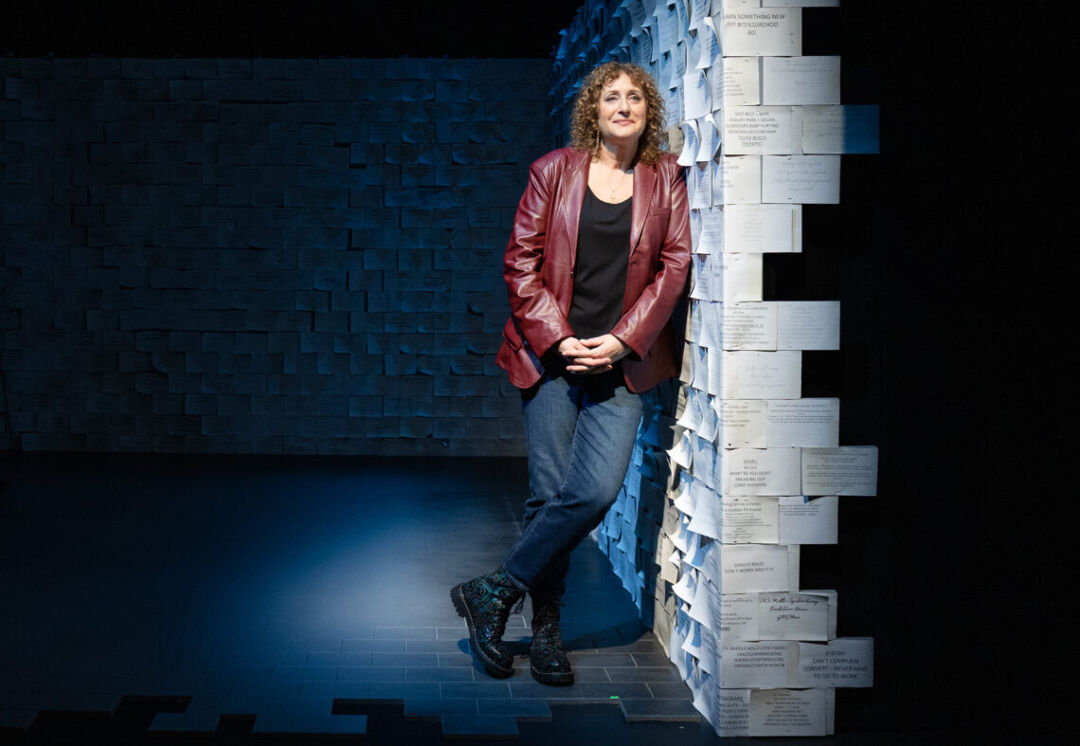 Judy Gold leans against the wall on the set of her Off-Broadway play, Yes, I Can Say That!