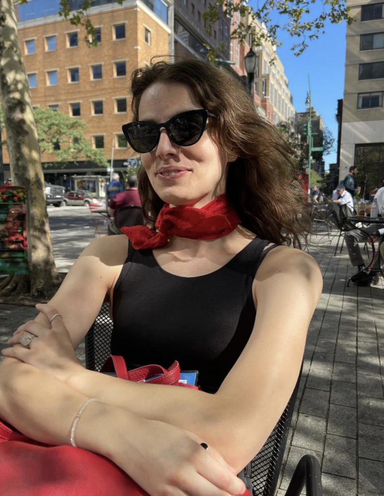 pedro pascal's sister, lux pascal sitting at in a metal chair outdoors