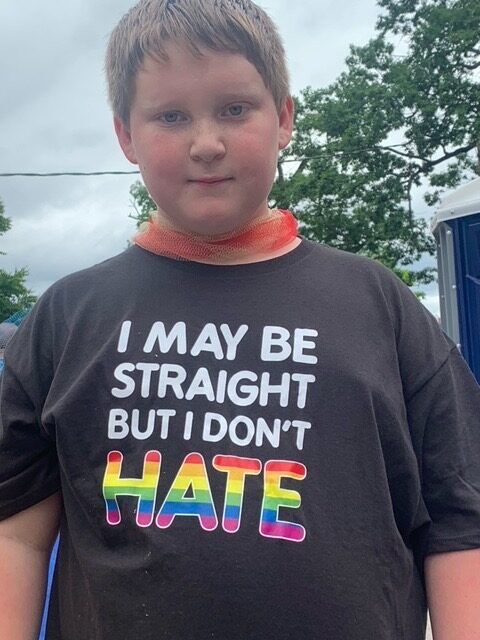 A teenaged parade-goer in Portland, Maine wears a t-shirt proclaiming, "I may be straight, but I don't hate."
