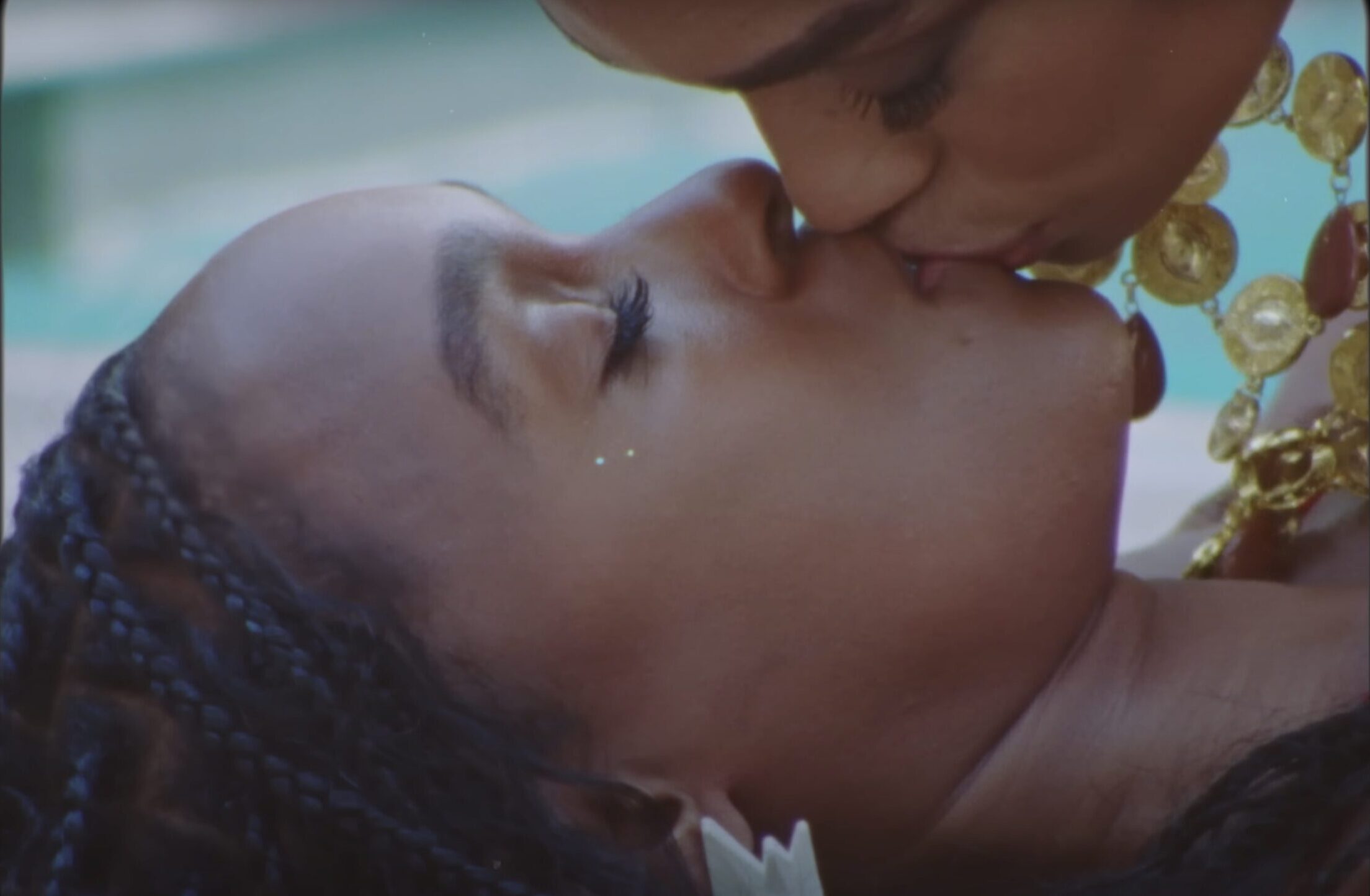 Janelle Monáe being kissed by a woman in the "Lipstick Lover" video