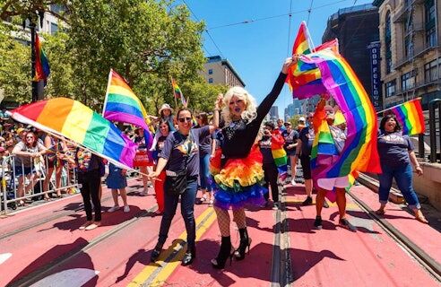 Colorful people carrying rainbow pride flags at SF Pride