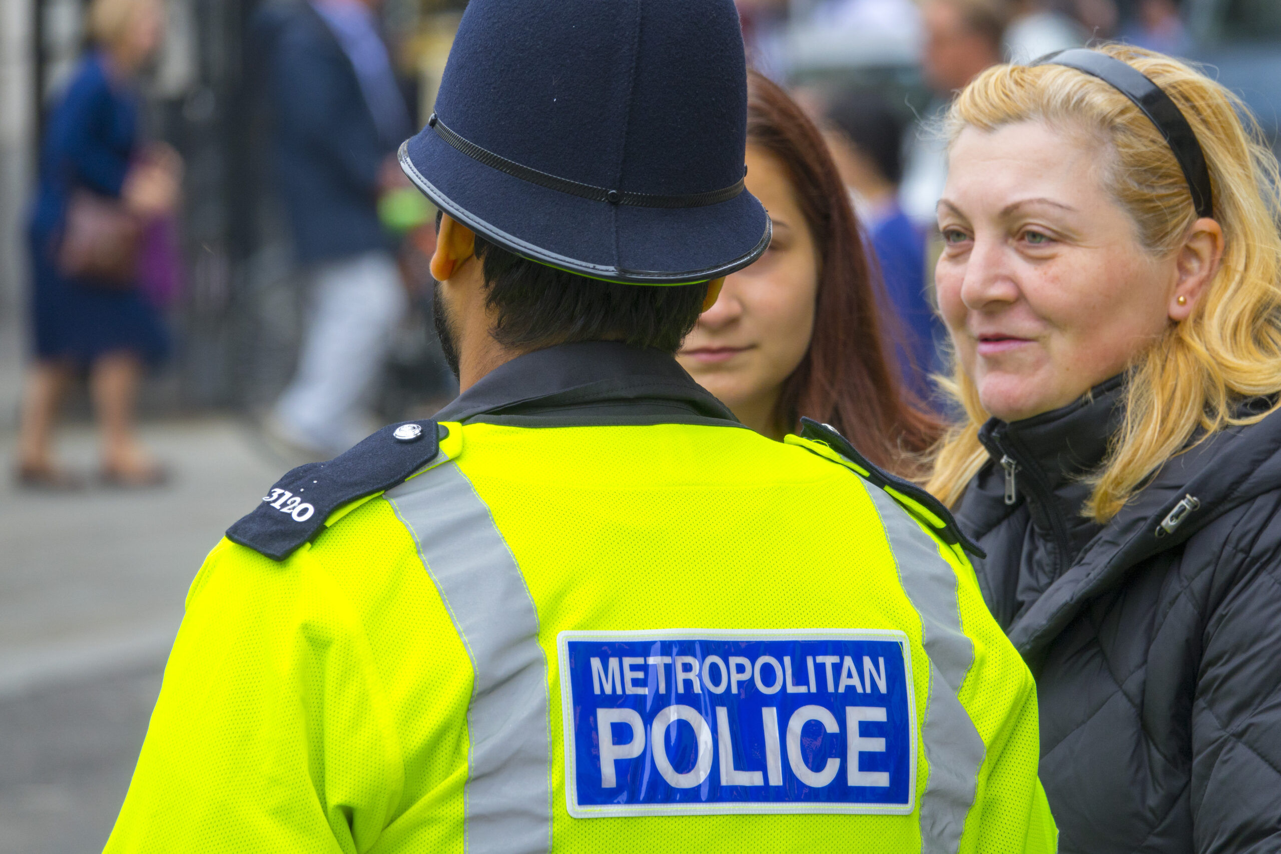 LONDON / ENGLAND - SEPTEMBER 23, 2016: A London Metropolitan Police officer talks to two women on the street