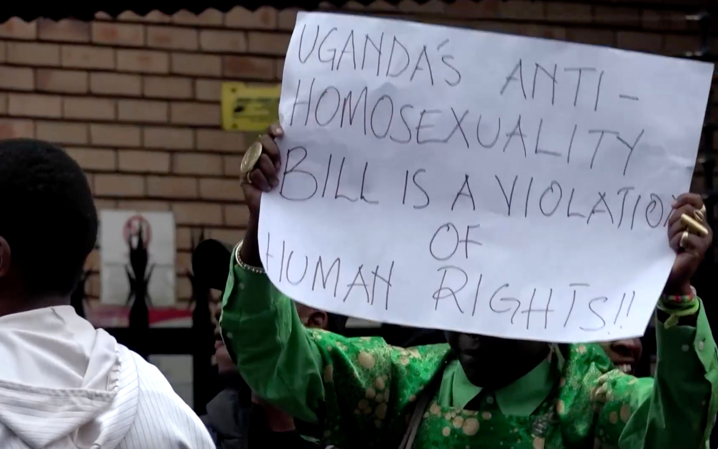 Activists hold signs protesting Uganda's "Anti-Homosexuality Act"