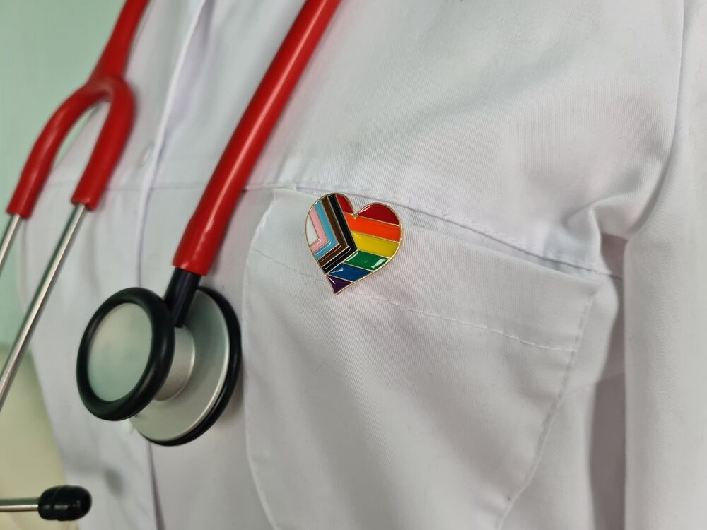 A doctor with a rainbow flag badge