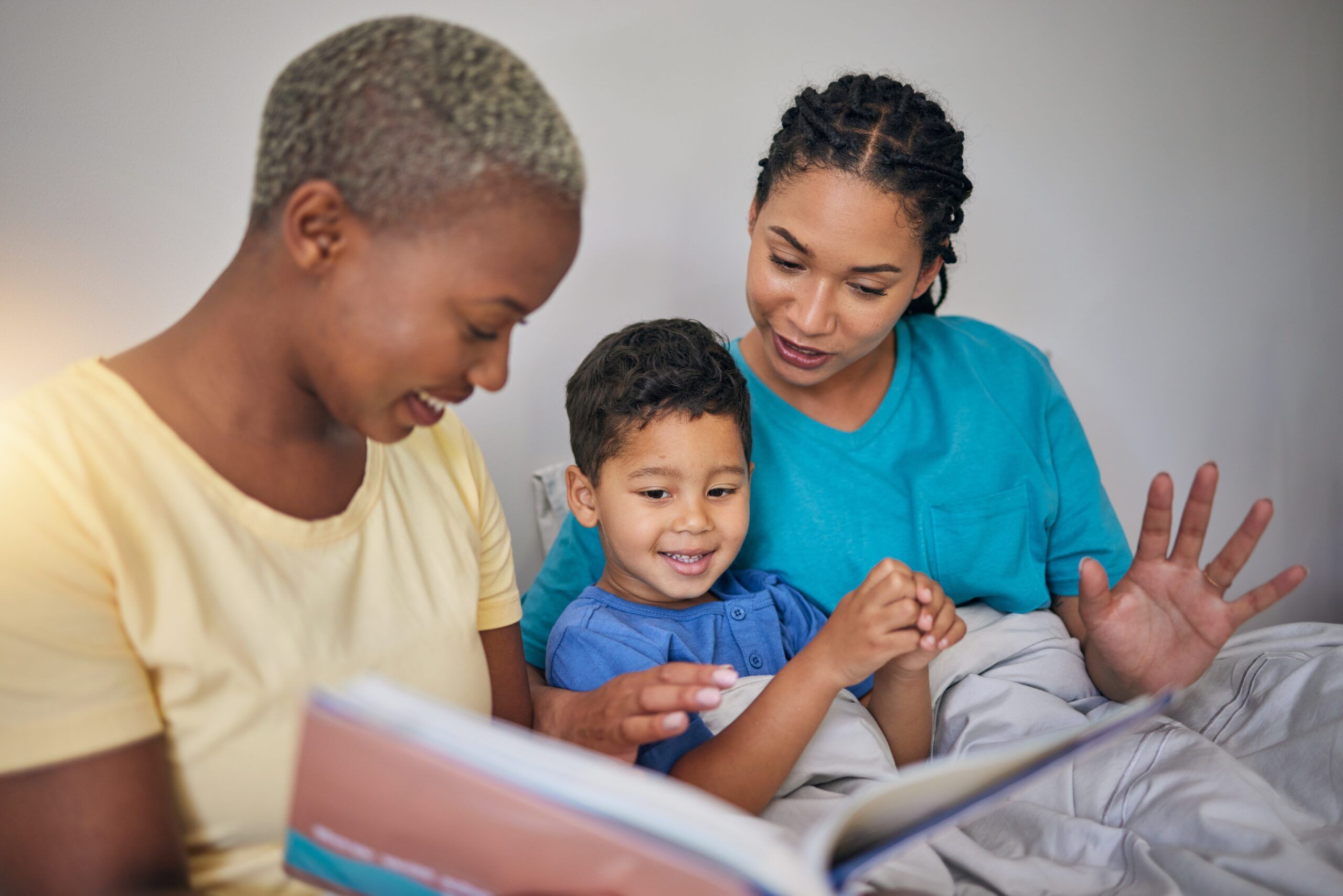 children's books, gay couple, lesbian couple, parents, Reading,,Lgbt,Family,And,Child,With,A,Book,In,Bed