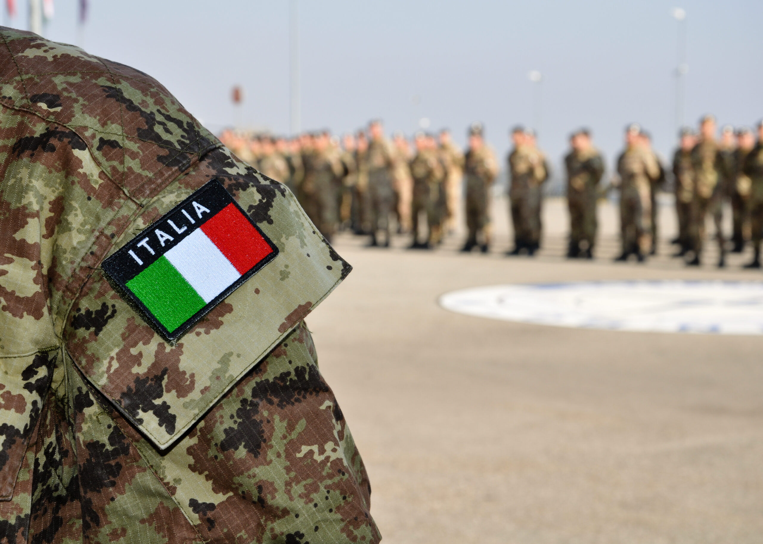 close up of an italian uniform with digital camouflage pattern and the national flag at a parade with KFOR troops in Kosovo