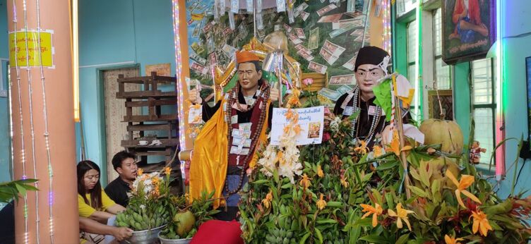 A young couple making offerings to the nats in Taung Kalat. It is widely believed that nats help improve life and create wealth when properly appeased. While people make routine offerings at nat shrines, nat worship rituals mediated by nat-kadaw spirit mediums are believed to be more efficacious. Historically, cisgender women acted as nat-kadaws but since the 1980s the profession has been dominated by meinmasha trans women. Photo by Soe Sandar Win
