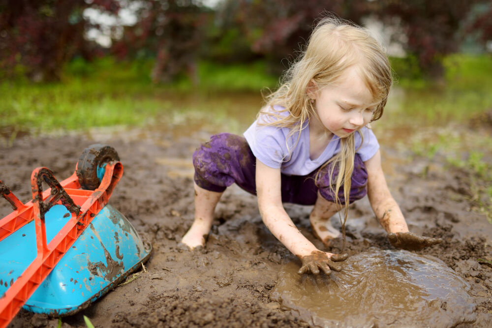 A girl playing in the mud