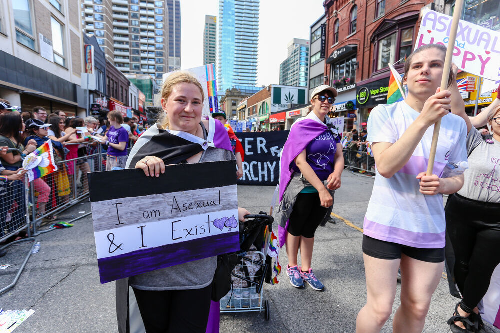 JUNE 25, 2017: ASEXUALS march, holding I AM ASEXUAL AND I EXIST sign, at 2017 Toronto Pride Parade.