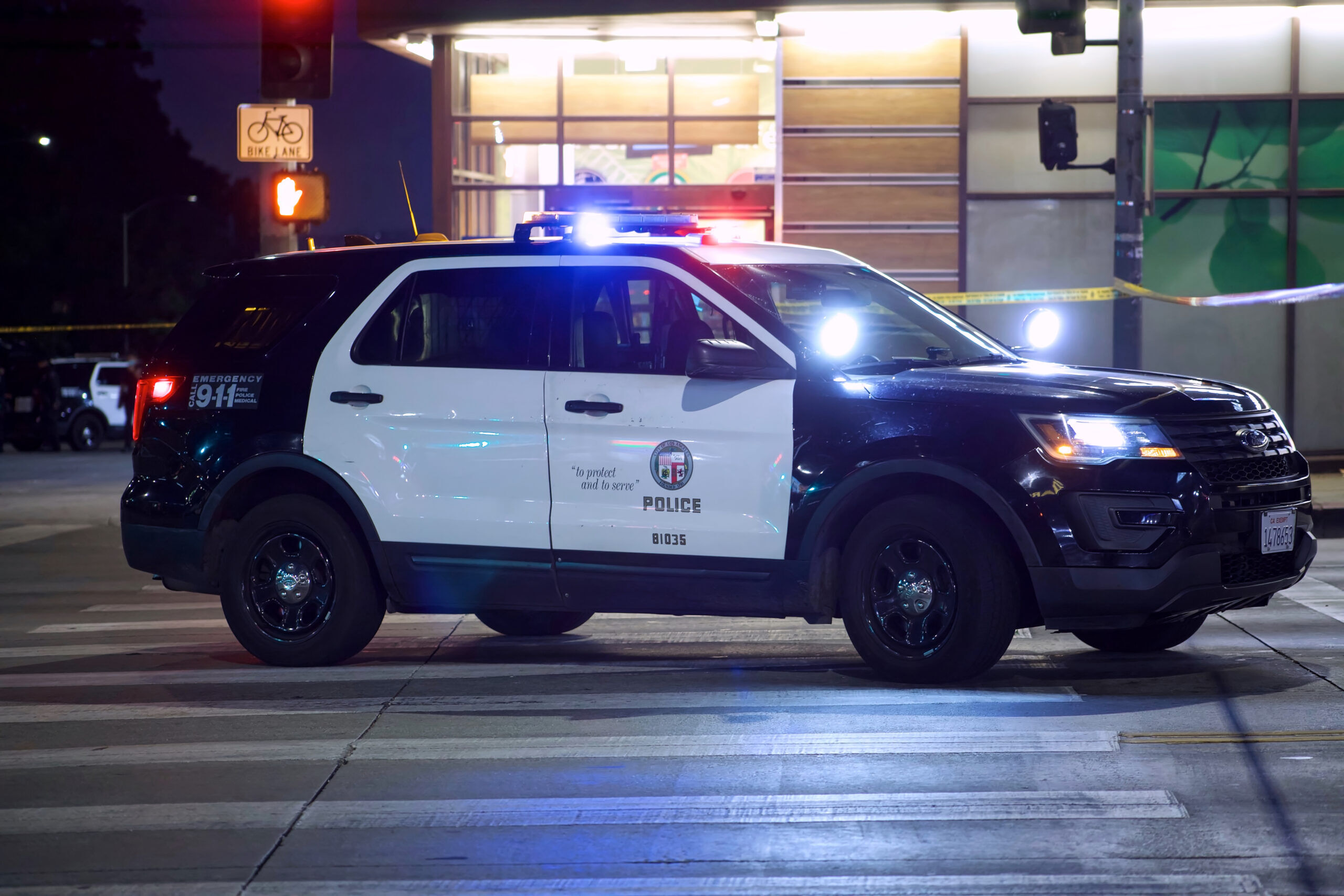 a police SUV has its colored lights on at night