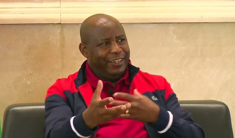 Burundi President Évariste Ndayishimiye is a black bald-headed man in a black and red athletic jacket