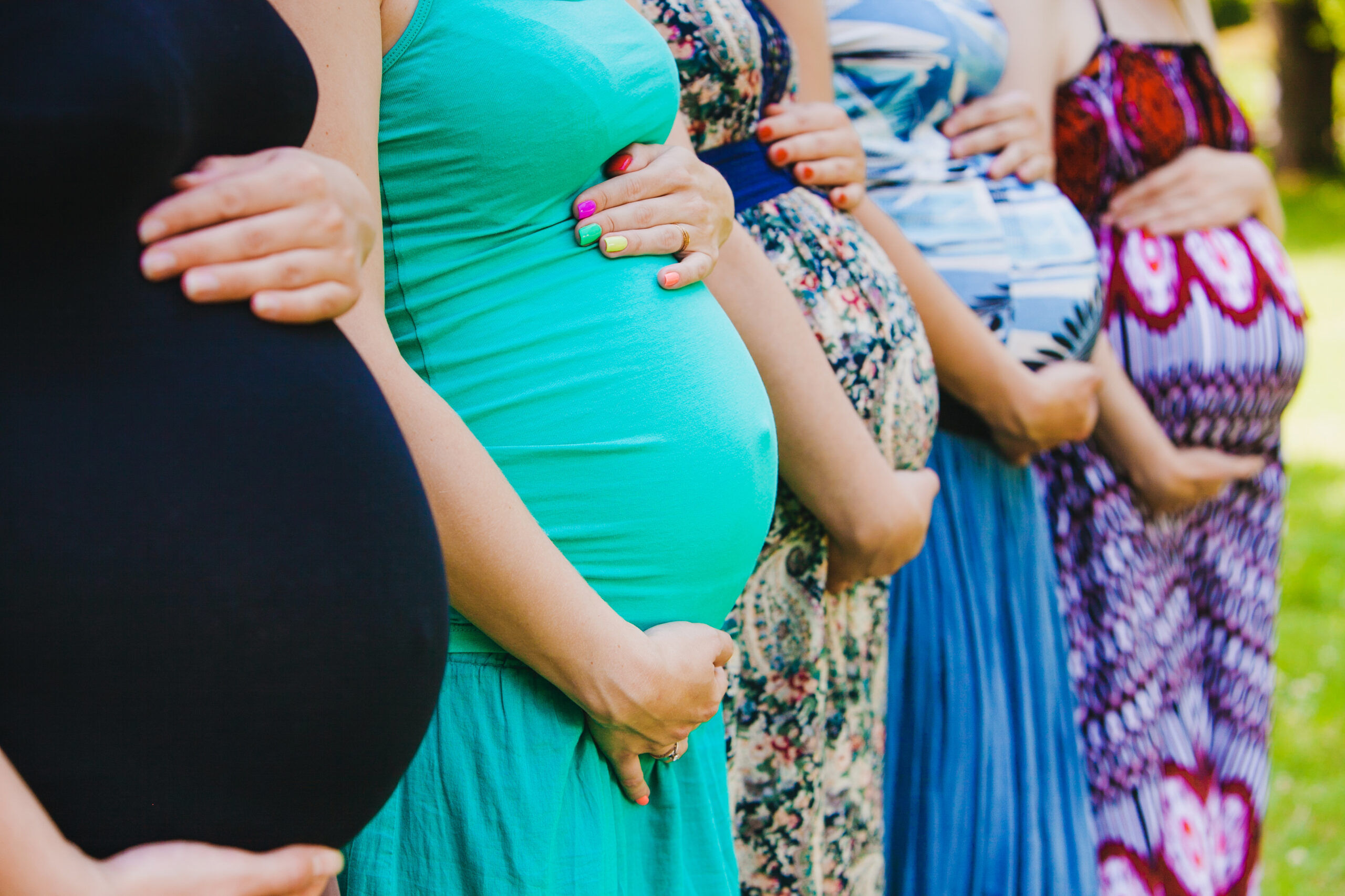 Closeup of group pregnant bellies. Five pregnant bellies.