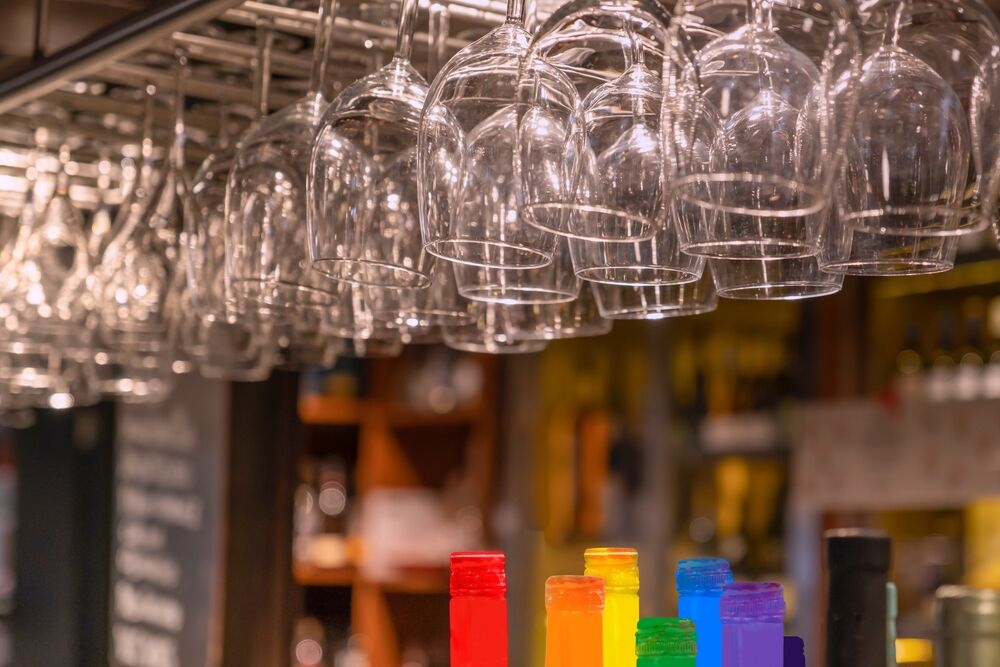 glasses and a rainbow, signifying a gay bar or an LGBTQ+ venue