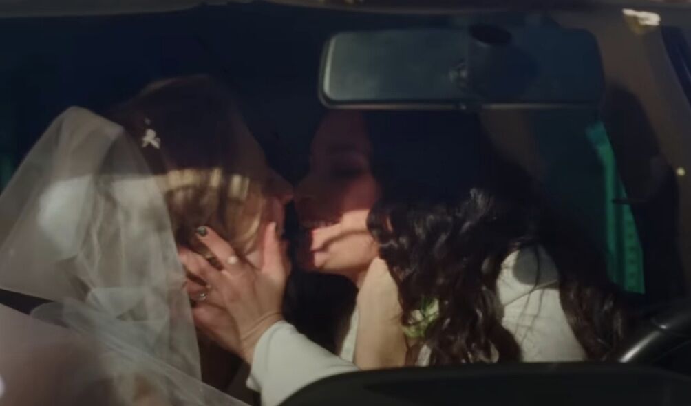 two lesbian newlyweds hold each other's faces lean in for a kiss in Volkswagen's Super Bowl ad